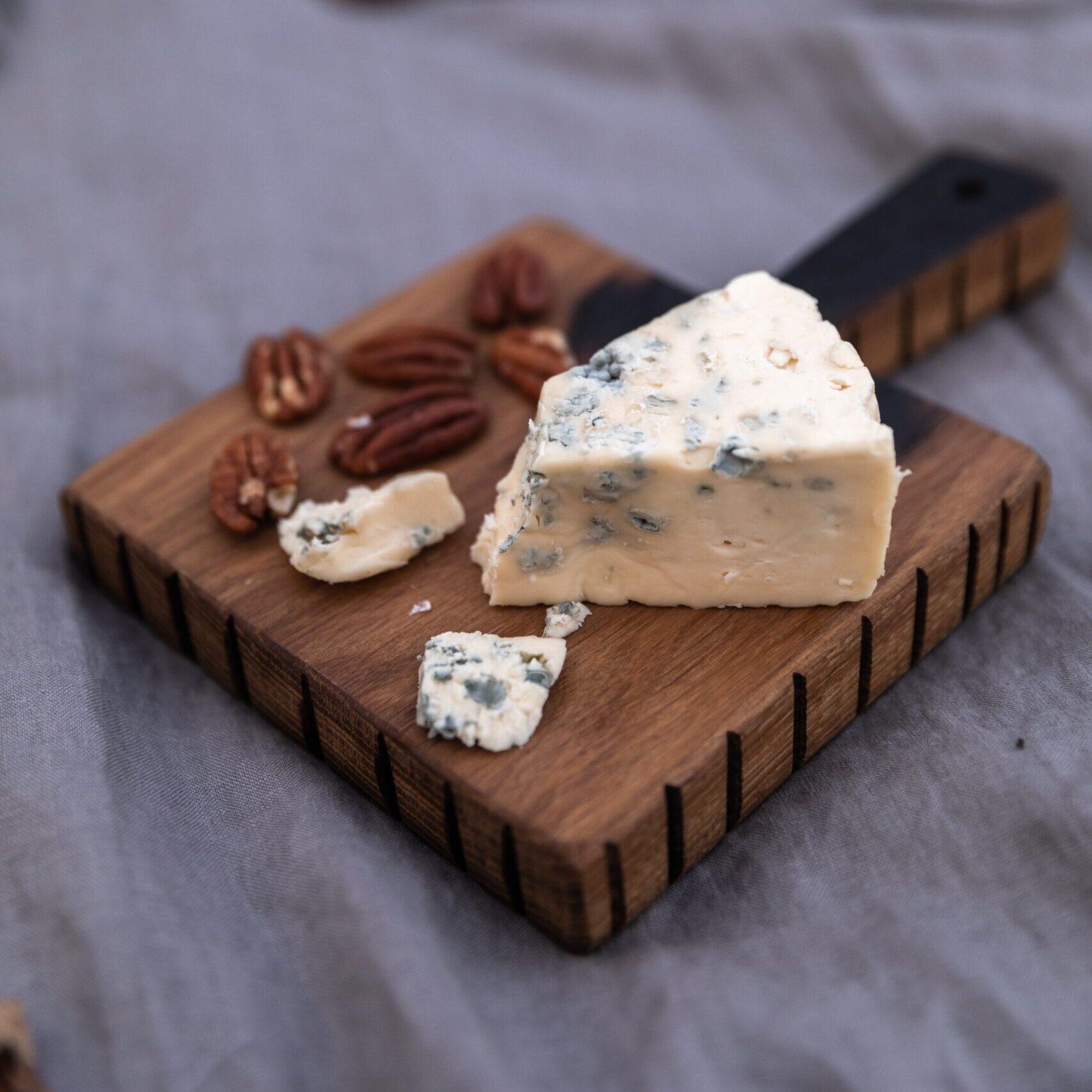 tabla de madera con queso azul francés y almendras